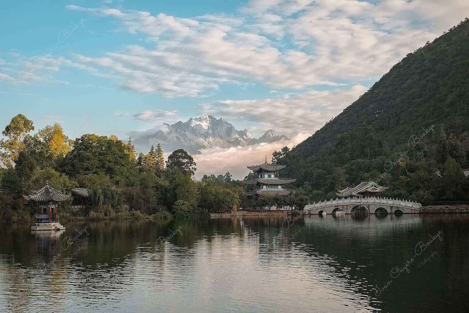 The Moon Embracing Pavilion, Suocui Bridge and Black Dragon Pool against the backdrop of the Jade Dragon Snow Mountain in Lijiang, China