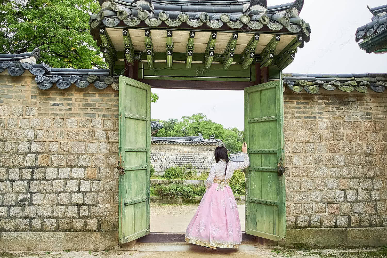 Asian woman wearing a pink traditional hanbok dress in Changdeokgung Palace, Seoul, South Korea